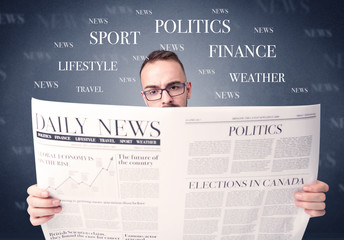 Young smart businessman reading daily newspaper