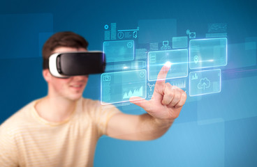 Young impressed man wearing virtual reality goggles with blue squares containing data at his...