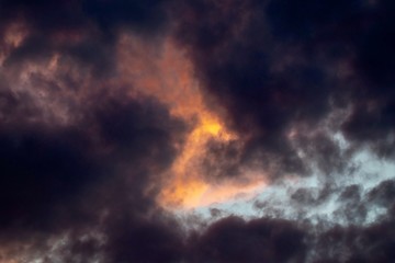 Fototapeta na wymiar Dramatic sky with orange sun and black clouds