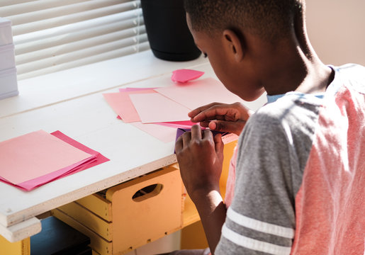 Young boy making heart Origami