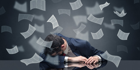 Young businessman fell asleep at the table with paperwork concept
