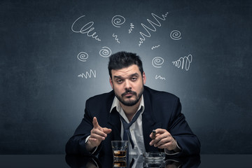 Young drunk man at his office with doodles around
