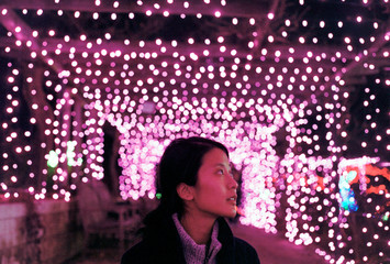 Young asian woman admiring pretty pink lights at night