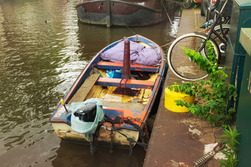 Old boat on the one of the water canals in the center of Amsterdam.