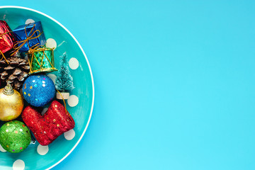 Polka dot plate of Xmas ornaments and decoration on blue background for Christmas day and holidays concept