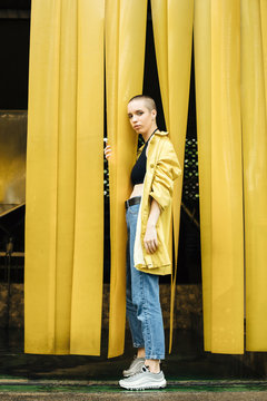 Stylish woman wearing a yellow jacket on the yellow background