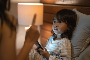 Mother warning little girl not to more play game