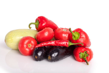 Tomatoes, red sweet peppers, chili peppers, eggplants, green zucchini in drops of water, sprinkles, drops of dew group on white background closeup isolated 