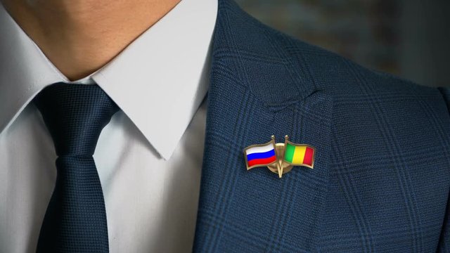 Businessman Walking Towards Camera With Friend Country Flags Pin Russia - Mali