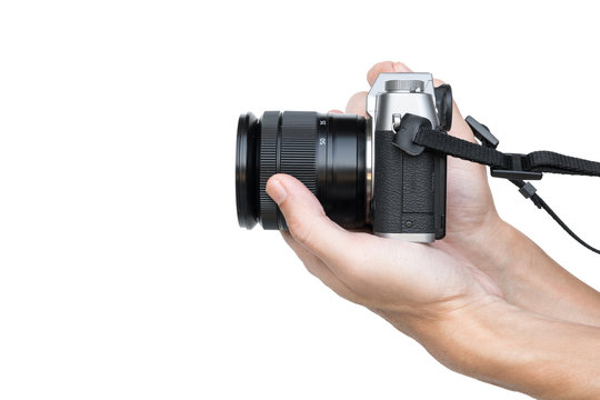 Hand shooting photo with mirrorless camera in side view isolated on white background