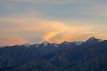 Fototapeta na wymiar pink orange sunset over the mountains with snowy peaks