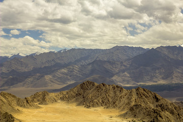 Canyon in desert mountains with snow peaks