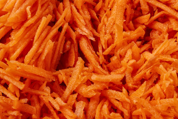 Fresh, juicy grated carrots close-up, for background.