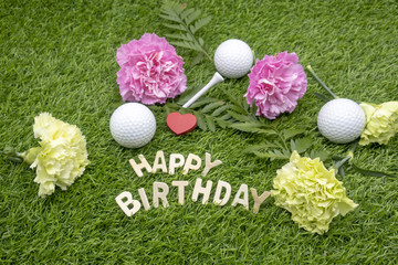 Happy Birthday to golfer with golf ball and flowers on grass