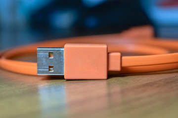 Orange USB cable with blurred background