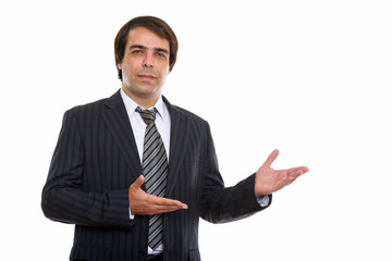 Studio shot of young Persian businessman showing something