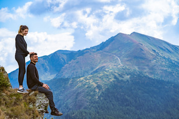 The happy man and a woman enjoying on the beautiful cliff