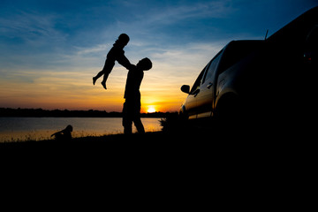 Father and son are playing on the lake at sunset. People have fun on the field. Family Friendly Concept and Summer Vacation
