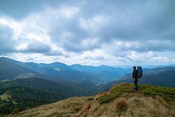 The man standing on the mountain on the cloud background