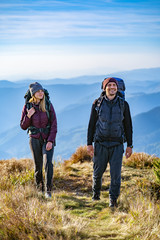 The happy man and a woman walking on the mountain