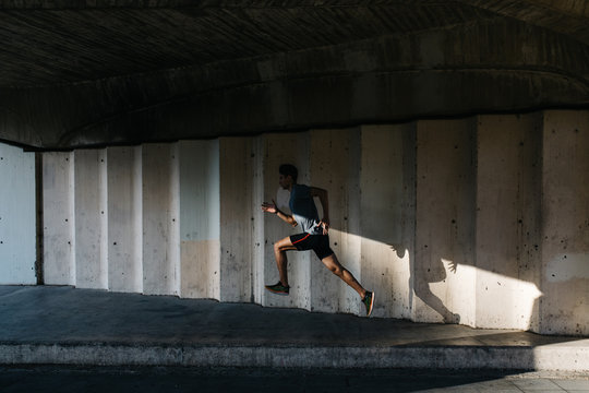 Sportsman running under bridge