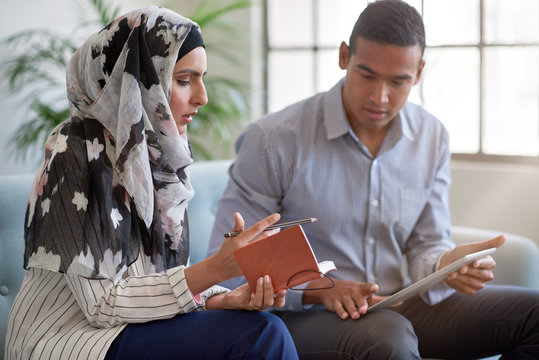 Businesswoman in headscarf having serious discussion