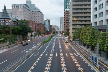 Fototapeta premium Big highway in urban modern city with cars on it and buildings and scyscrappers from both sides