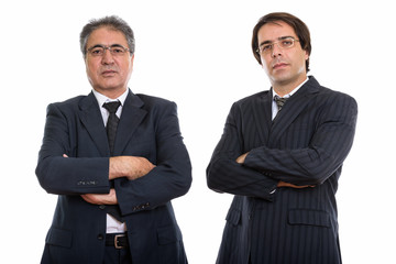 Studio shot of young and senior Persian businessman with arms cr