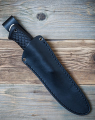 hunting knife in a leather scabbard