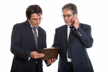 Young Persian businessman reading on clipboard together with sen © Ranta Images