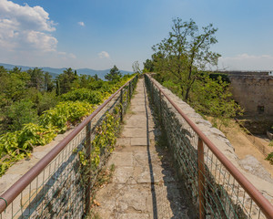 Fototapeta na wymiar Patrol path on top of the walls of Fortress Girifalco, in Cortona, Italy