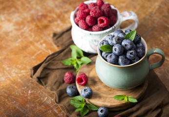 blueberries and raspberries on a wooden background