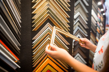Beautiful young caucasian woman choosing the right item for her apartment in a modern home decor