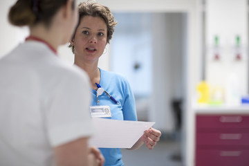 Two nurses talking in a hallway