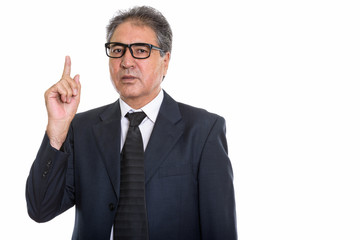 Studio shot of senior Persian businessman wearing eyeglasses and