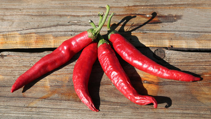 four spicy red peppers on a table