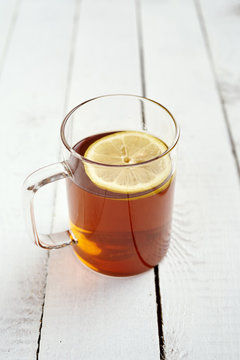 delicious hot tea with honey and lemon on an old white wooden table