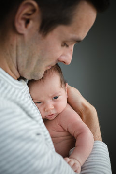 Content new dad holding baby at home snuggling