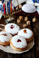 Tasty donuts with jam on wooden background - Hanukkah celebration concept 