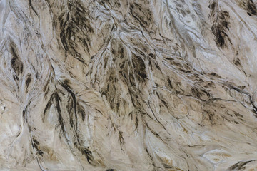 Top down view on abstract patterns and shapes of mineral waste rivers from power plant.