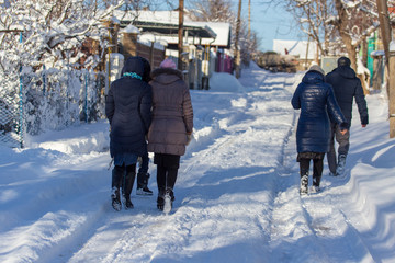 People go on a snowy road in winter