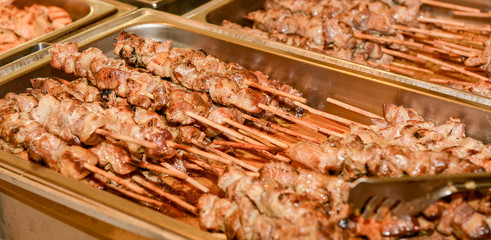 silver plates filled with plenty souvlaki sticks.