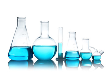 Laboratory glassware with liquid on table against white background. Chemical analysis
