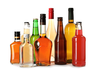 Bottles with different alcoholic drinks on white background