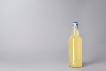 Bottle of alcoholic drink on grey background. Space for text