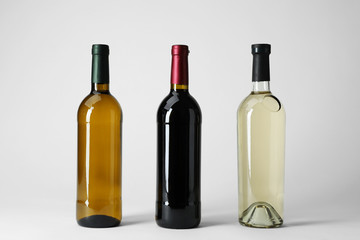 Fototapeta na wymiar Bottles with different types of wine on light background