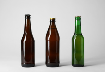 Bottle with different types of beer on light background