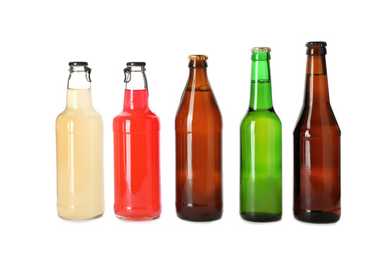 Bottles with different alcoholic drinks on white background