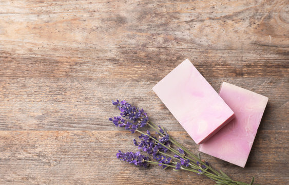 Flat lay composition with handmade soap bars, lavender and space for text on wooden background