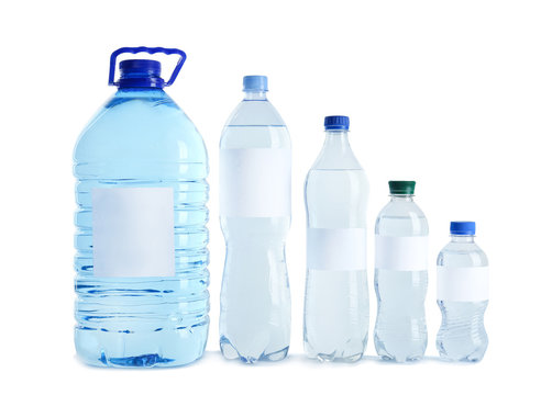Different bottles of pure water with blank tags on white background